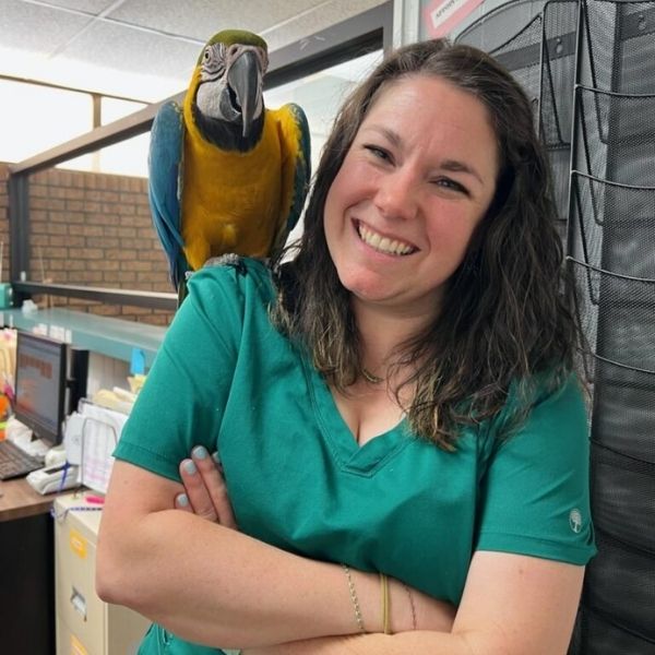 vet staff with a bird on her shoulder